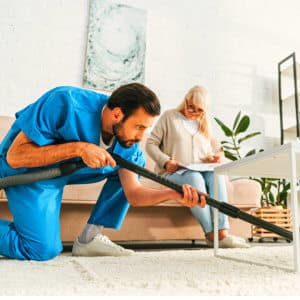 caregiver cleaning a carpet