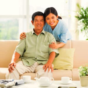 caregiver with elder man sitting on a couch