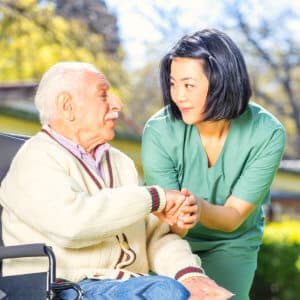 caregiver and elder man outdoors