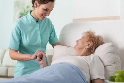 a nurse holding the hand of an elderly