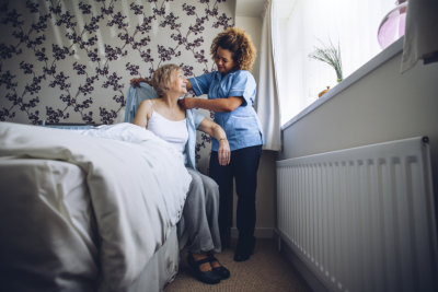 a nurse giving an old lady a blanket