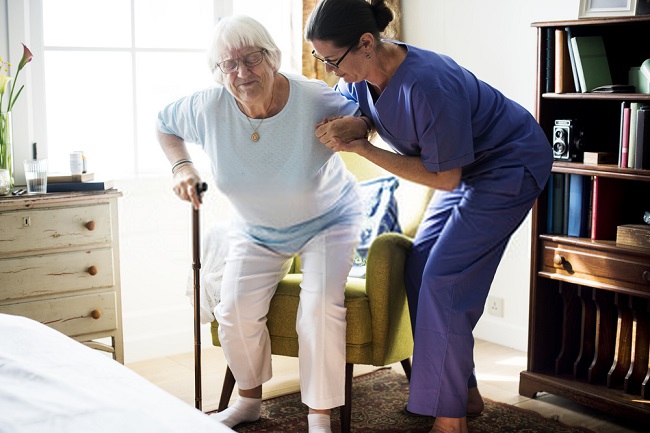an elderly being helped by a nurse