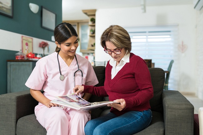 a woman and a nurse looking at a photo album