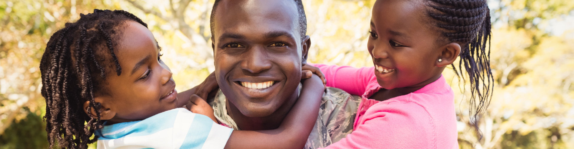 a veteran smiling with two kids