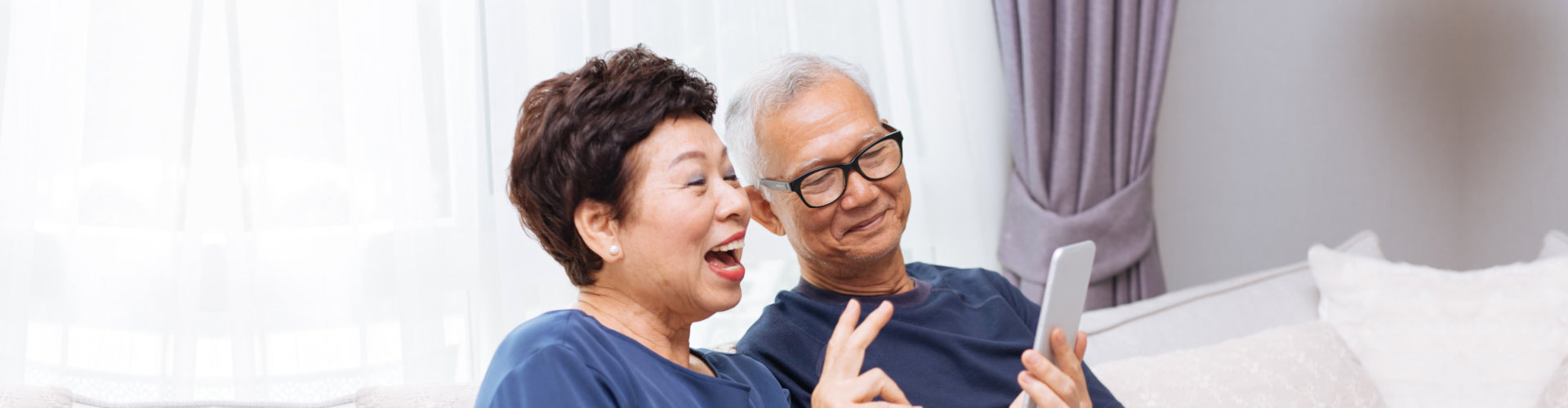 a woman and an elderly looking at the phone