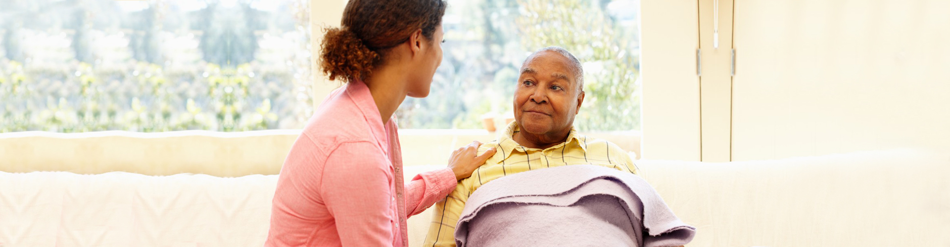 caregiver with elder man on bed