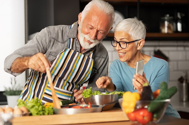 an elderly couple making salad